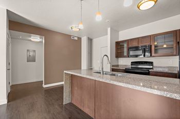A kitchen with brown cabinets and a granite countertop.